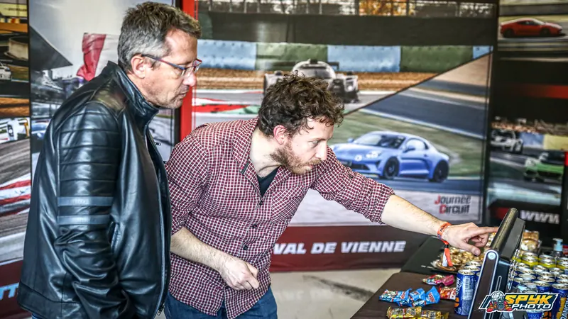 Un partecipante tocca uno schermo dello stand per ritrovare le sue foto, accanto a un’altra persona.